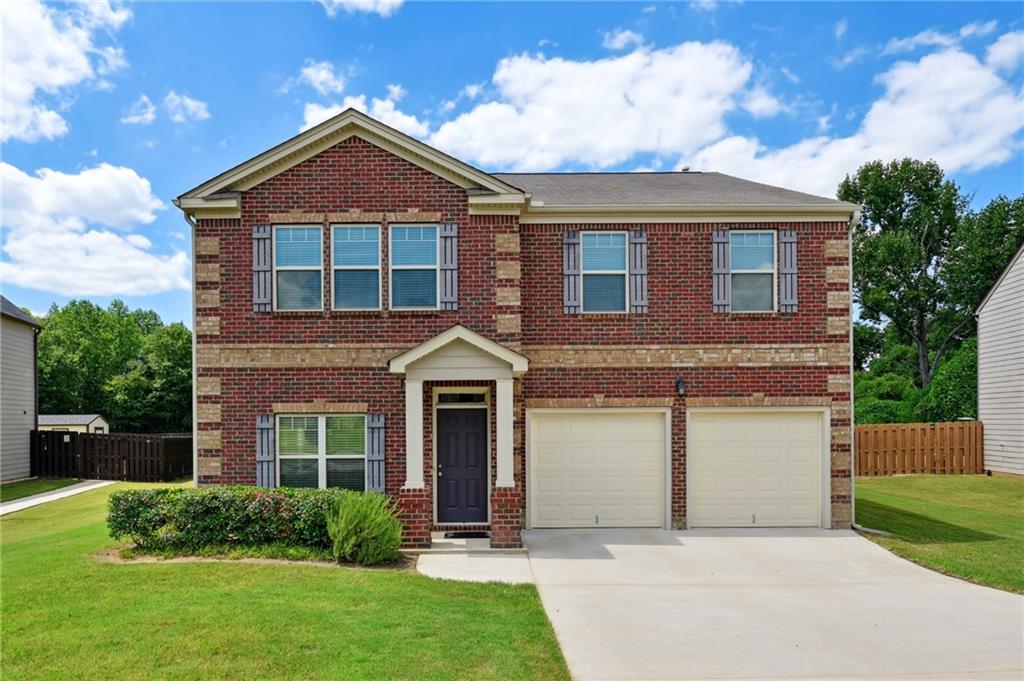 a front view of a house with a yard and garage