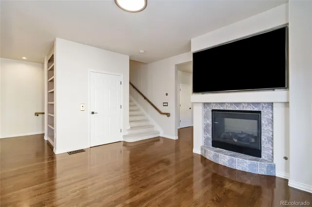 an empty room with wooden floor and fireplace