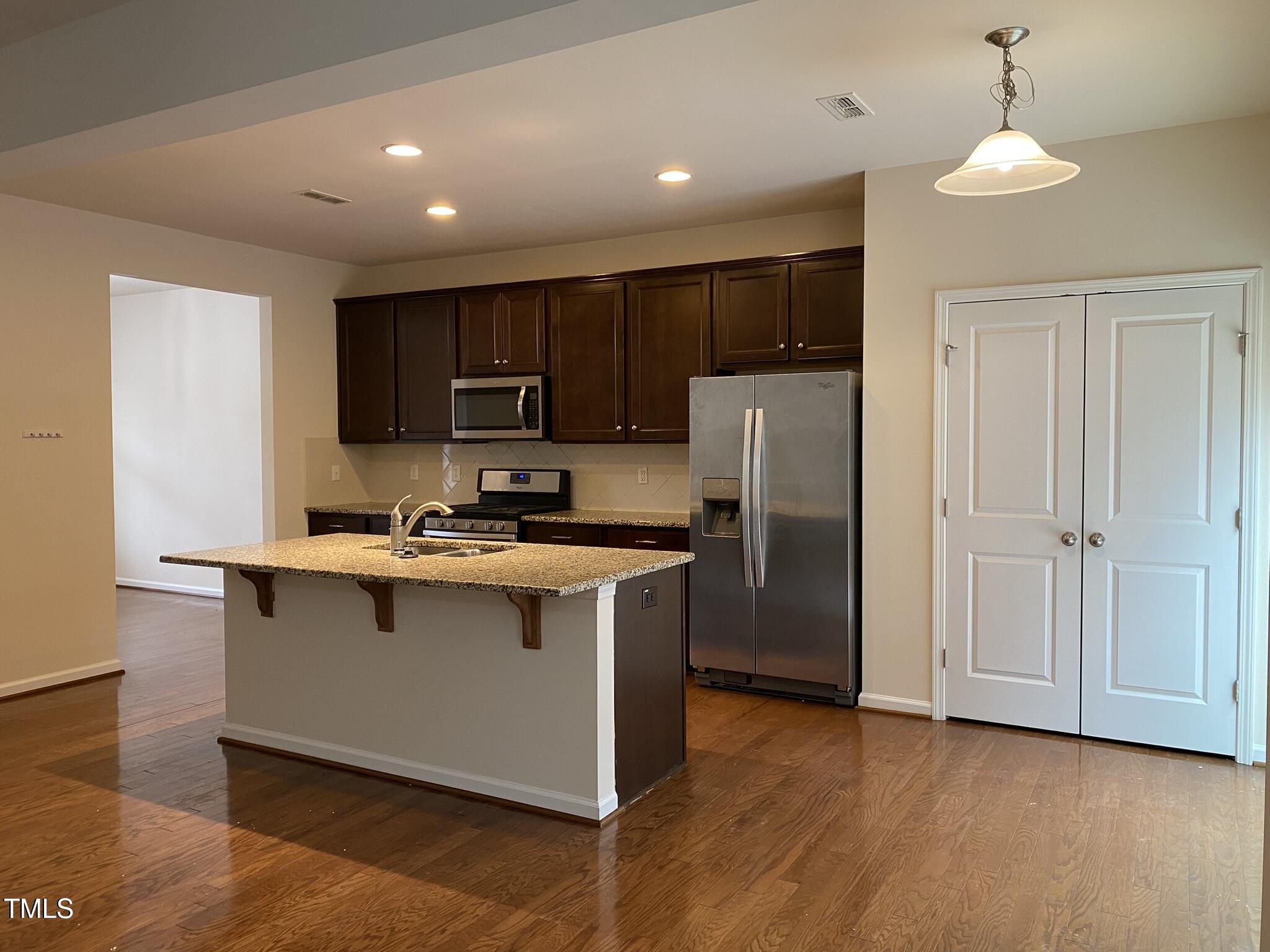 3545 Massey Ridge Court Raleigh, NC 27616 - Photo 10 of 38 a kitchen with kitchen island a sink and a refrigerator