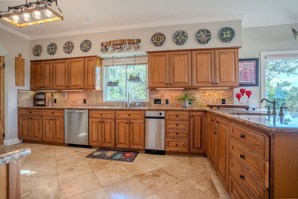 1950 Estrellita Ranch Road Canyon Lake, TX 78133 - Photo 19 of 34 a kitchen with kitchen island wooden cabinets a window a sink and a counter space