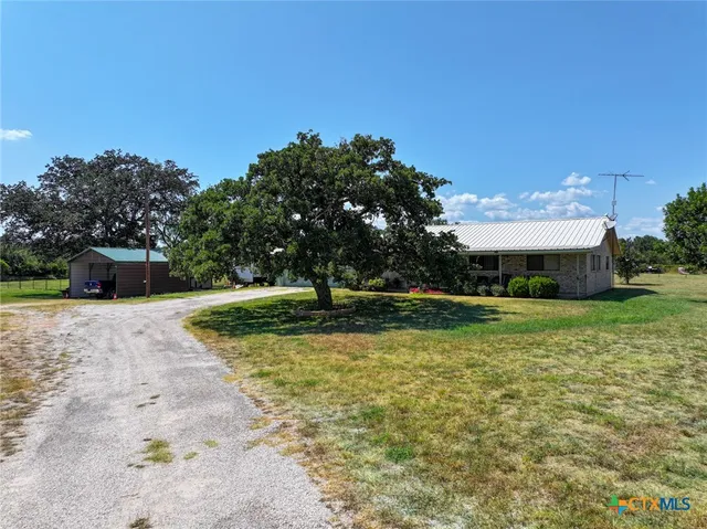 a view of a fountain in front of a house with a yard