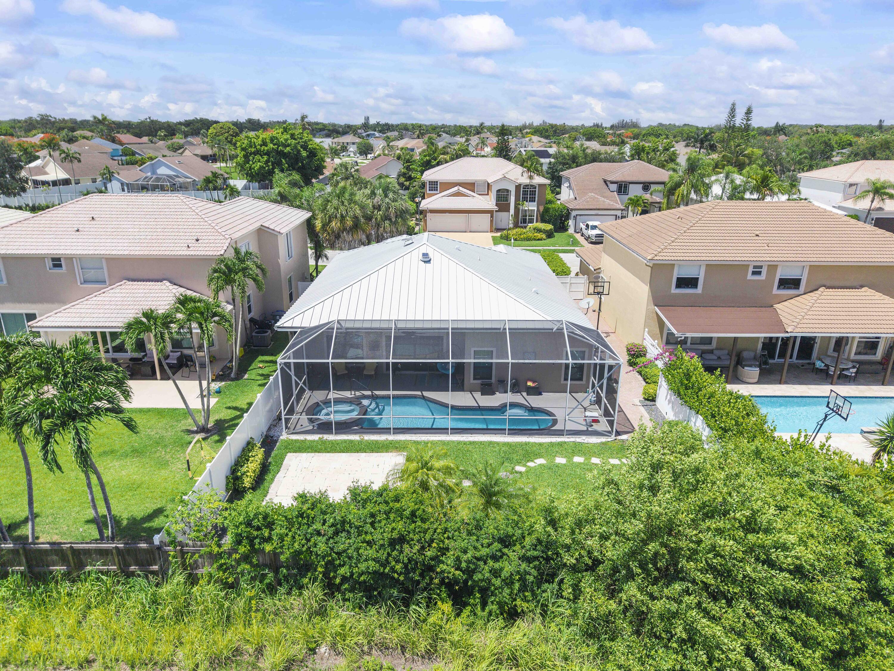 12328 St Simon Drive Boca Raton, FL 33428 - Photo 4 of 52 an aerial view of a house with a big yard and palm trees