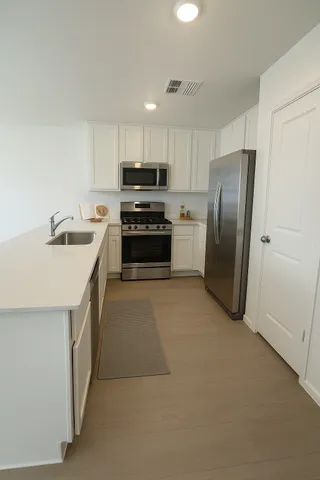 a kitchen with stainless steel appliances granite countertop a refrigerator a stove a sink and a microwave