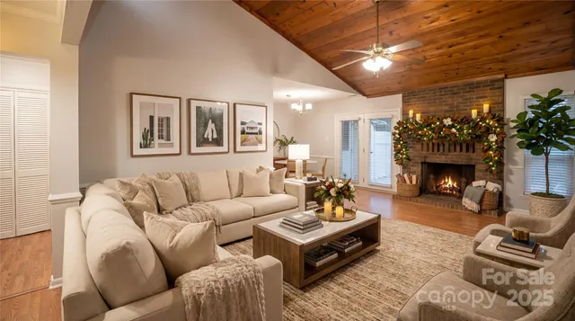 a living room with furniture a fireplace and a dining table with wooden floor