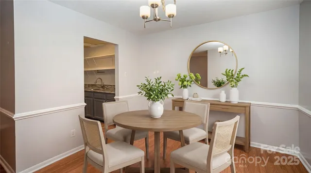 a dining room with furniture potted plants and wooden floor