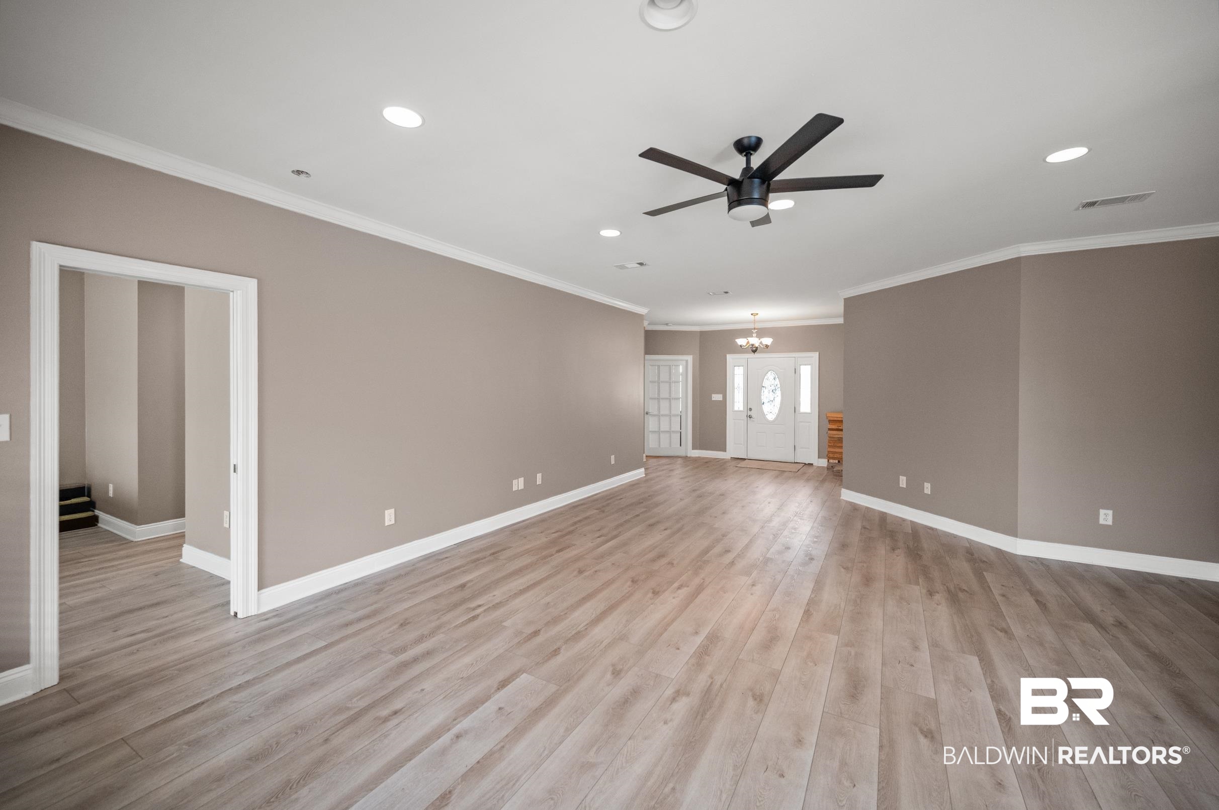 108 Natchez Trace Foley, AL 36535 - Photo 15 of 35 Unfurnished room featuring ceiling fan with notable chandelier, crown molding, and light hardwood / wood-style flooring