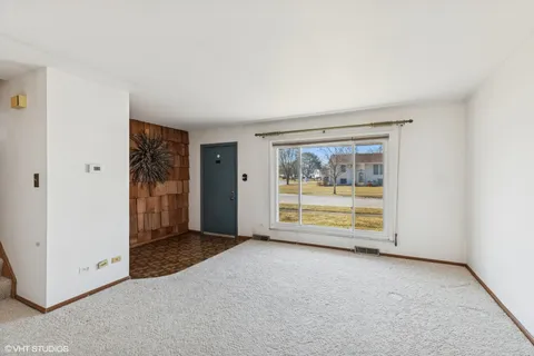 an empty room with a fireplace and window