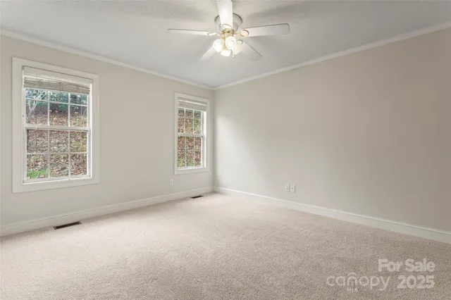 an empty room with windows and fan