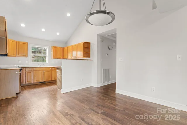 a view of a kitchen with a sink dishwasher and wooden floor