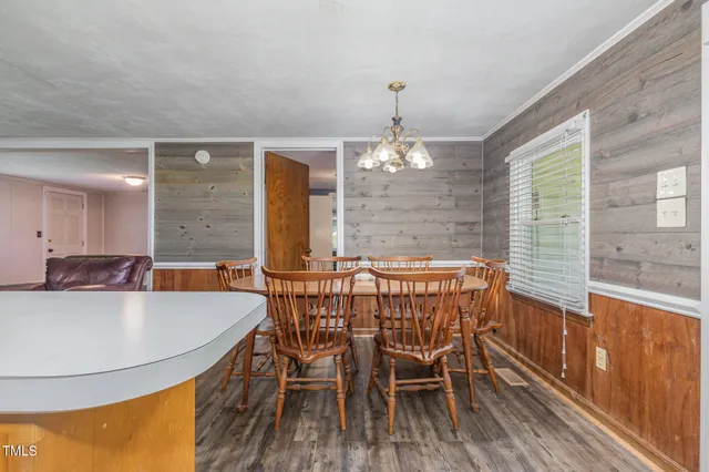 a kitchen with stainless steel appliances granite countertop a stove a sink dishwasher and white cabinets with wooden floor