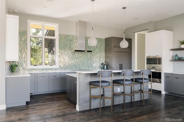 a kitchen with granite countertop a table chairs stove a sink and dishwasher