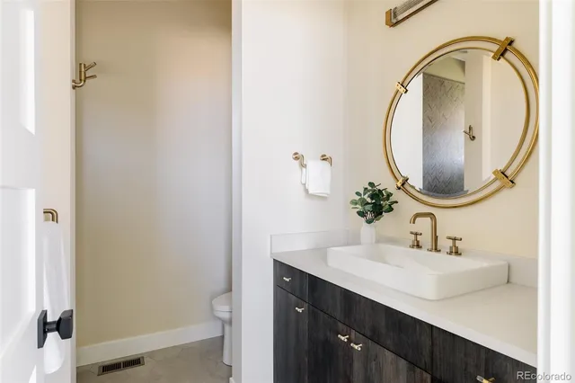 a bathroom with a sink a toilet and a mirror