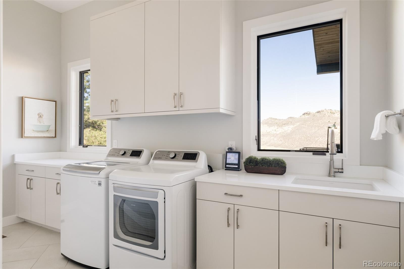 15480 Dinosaur Ridge Road Morrison, CO 80465 - Photo 20 of 50 a kitchen with a sink stove and white cabinets