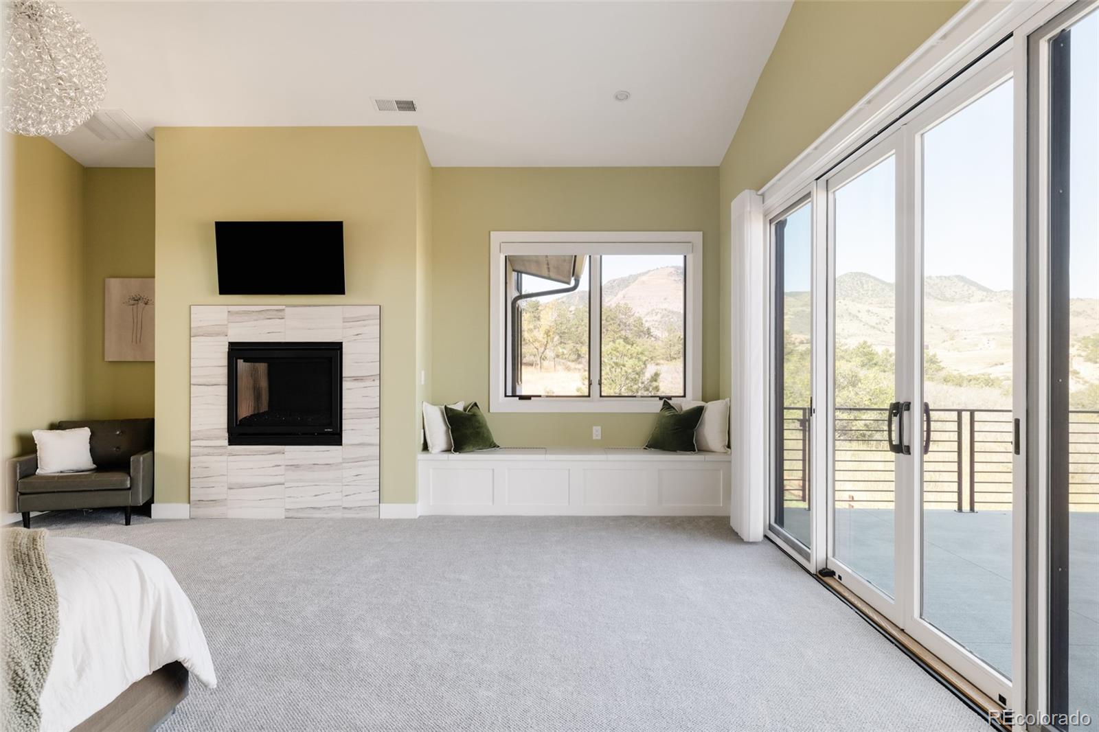 15480 Dinosaur Ridge Road Morrison, CO 80465 - Photo 25 of 50 a large bedroom with furniture fireplace and window