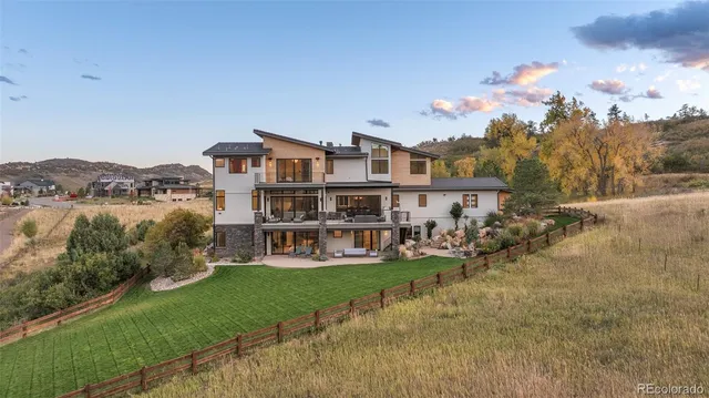 a view of a house with a big yard and large trees