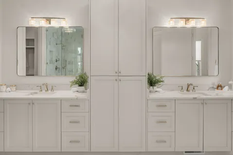 a bathroom with cabinets sink and mirror