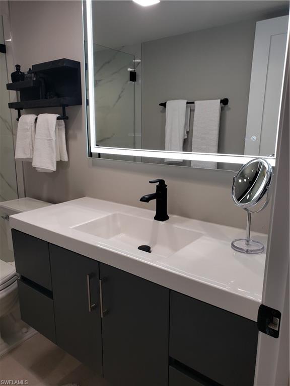 5435 Rattlesnake Hammock Road, Unit E102 Naples, FL 34113 - Photo 12 of 32 a bathroom with a sink and a mirror