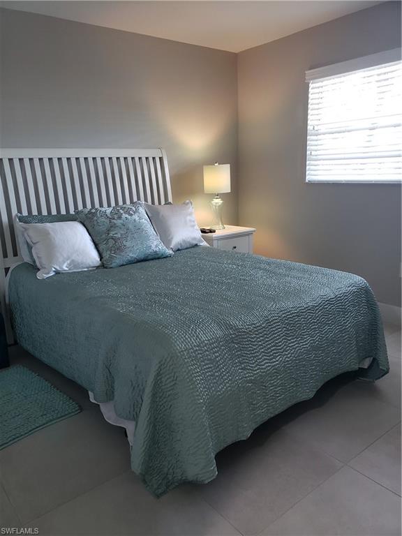 5435 Rattlesnake Hammock Road, Unit E102 Naples, FL 34113 - Photo 15 of 32 a bed sitting in a bedroom next to a window