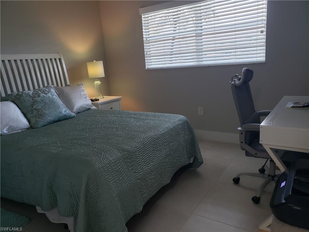 5435 Rattlesnake Hammock Road, Unit E102 Naples, FL 34113 - Photo 16 of 32 a bedroom with a bed and a window