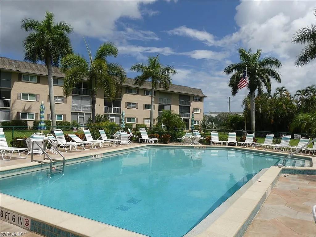5435 Rattlesnake Hammock Road, Unit E102 Naples, FL 34113 - Photo 32 of 32 a view of a swimming pool with lounge chairs