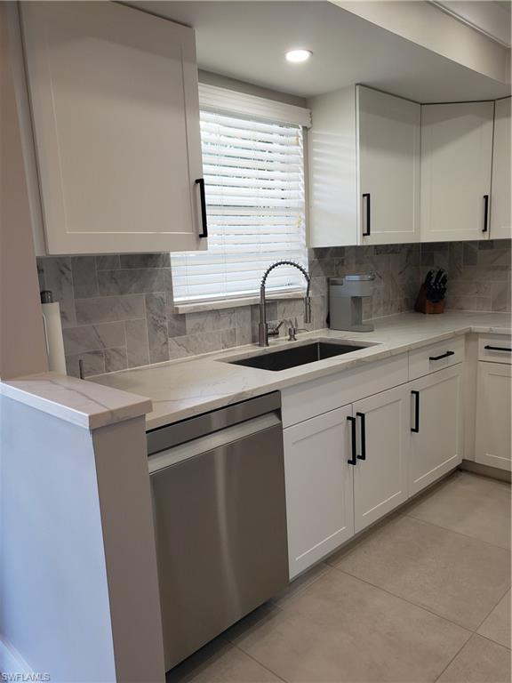 5435 Rattlesnake Hammock Road, Unit E102 Naples, FL 34113 - Photo 4 of 32 a kitchen with stainless steel appliances granite countertop white cabinets sink and window