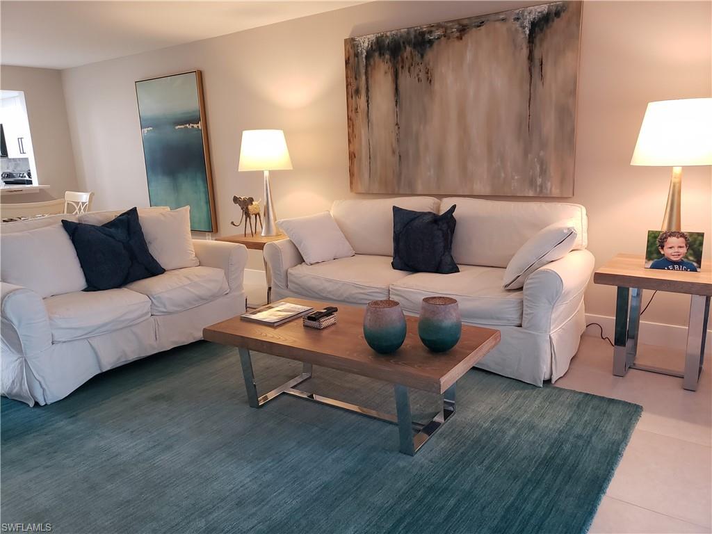 5435 Rattlesnake Hammock Road, Unit E102 Naples, FL 34113 - Photo 6 of 32 a living room with furniture and a lamp