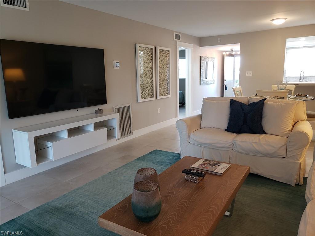 5435 Rattlesnake Hammock Road, Unit E102 Naples, FL 34113 - Photo 7 of 32 a living room with furniture and a flat screen tv