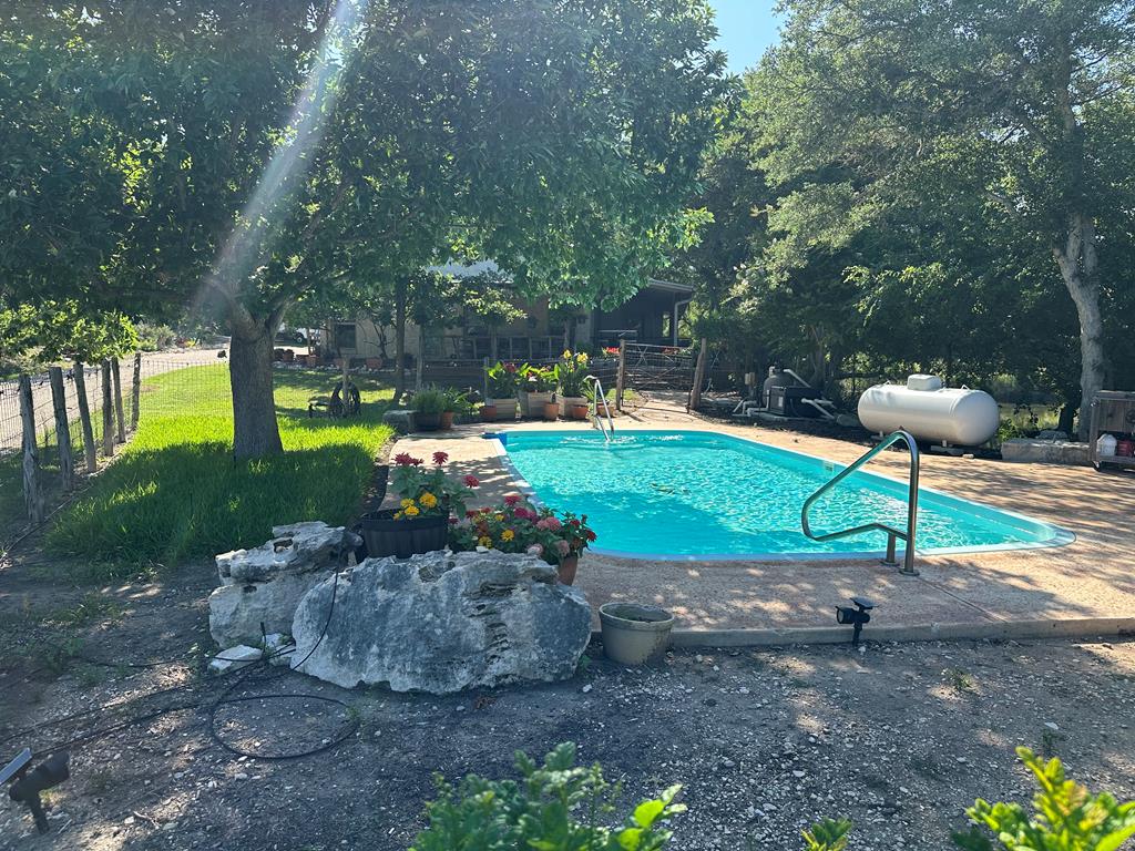 290 Cardinal Hill Road Ingram, TX 78025 - Photo 28 of 57 a swimming pool with a garden and outdoor seating