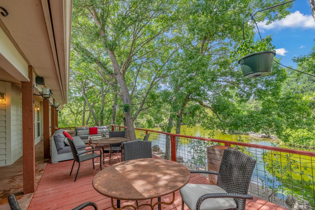 290 Cardinal Hill Road Ingram, TX 78025 - Photo 4 of 57 a balcony with wooden floor table and chairs
