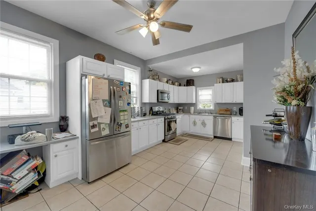 a kitchen with a refrigerator a sink dishwasher stove and white cabinets