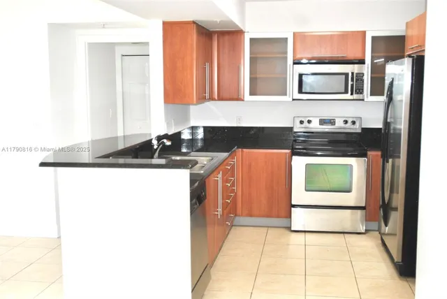 a kitchen with stainless steel appliances granite countertop a stove a sink and a microwave