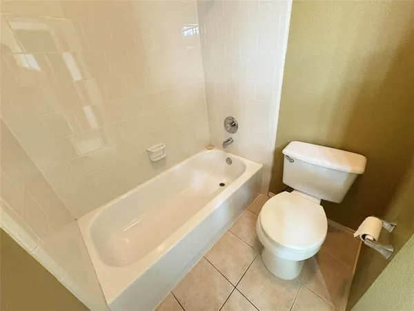 a white toilet sitting next to a bath tub