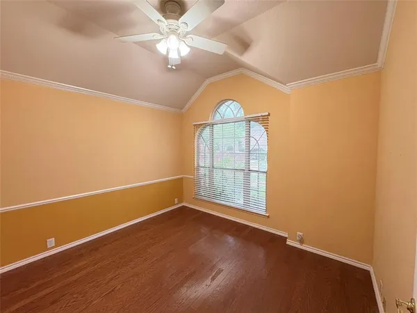 an empty room with windows and ceiling fan