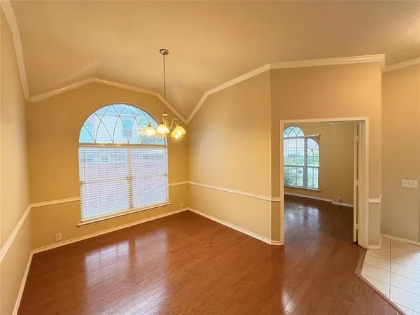 an empty room with wooden floor door and windows
