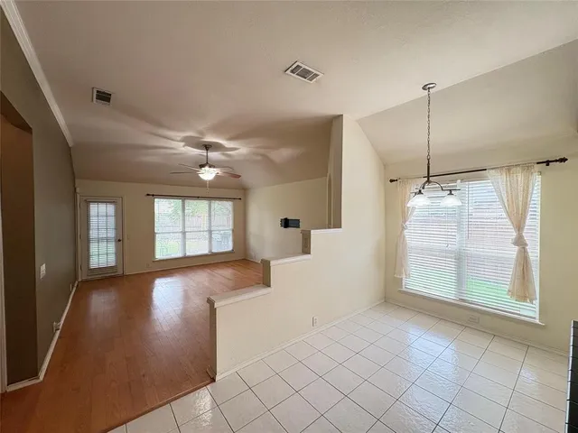 a view of an empty room with window and cabinet area