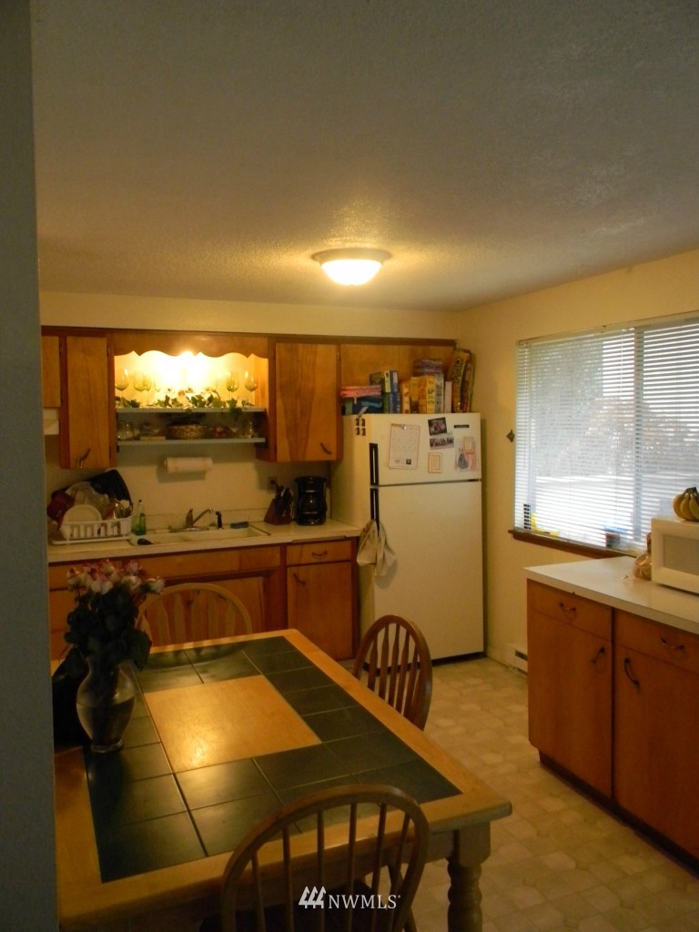 515 Roe Street Steilacoom, WA 98388 - Photo 4 of 9 a kitchen with a sink a stove and a refrigerator