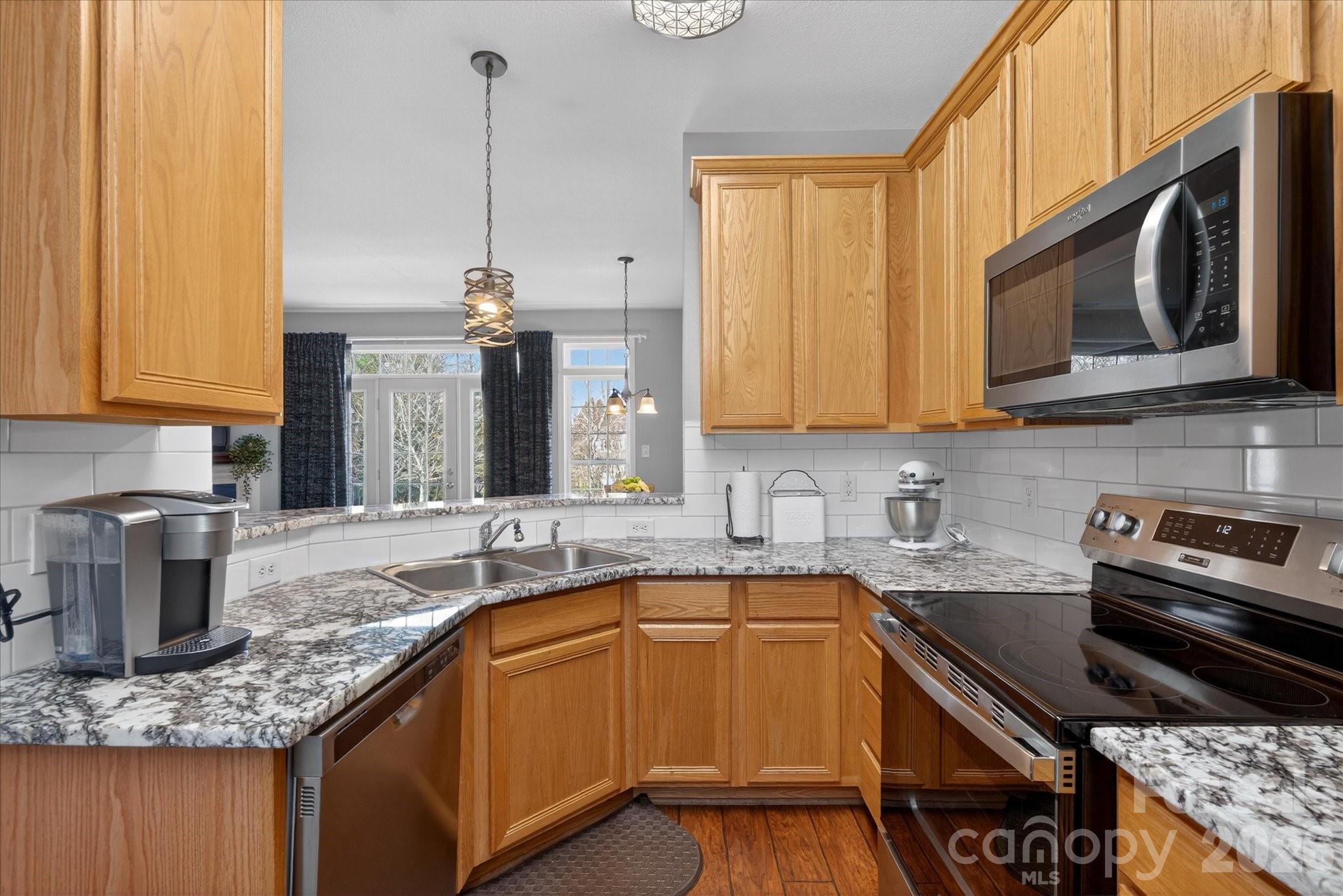 3066 Priory Ridge Drive, Unit 337 Fort Mill, SC 29707 - Photo 9 of 31 a kitchen with stainless steel appliances granite countertop a sink a stove and a microwave
