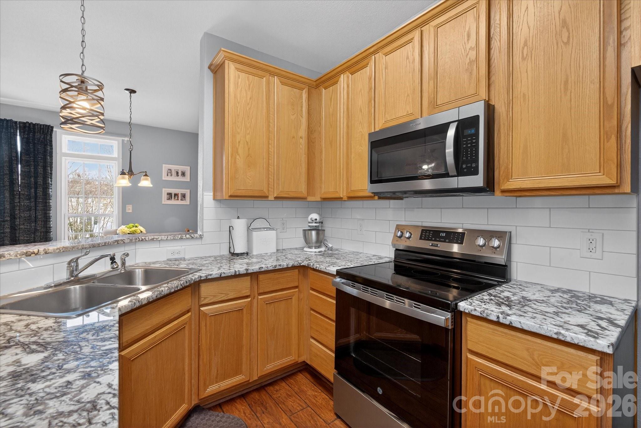 3066 Priory Ridge Drive, Unit 337 Fort Mill, SC 29707 - Photo 10 of 31 a kitchen with stainless steel appliances granite countertop a sink stove and microwave