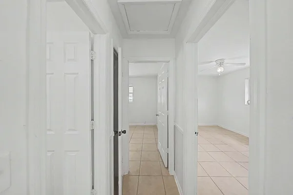 an empty room with windows and fan