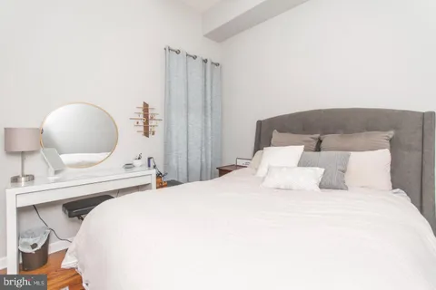 a bedroom with a bed a mirror and a lamp