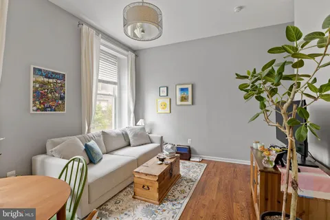 a living room with furniture a clock and a window