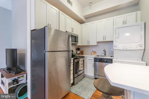 a kitchen with stainless steel appliances granite countertop a refrigerator stove and sink