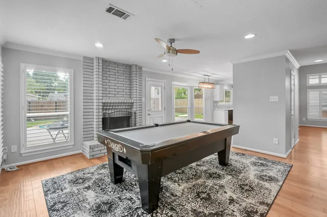 a room with pool table and windows