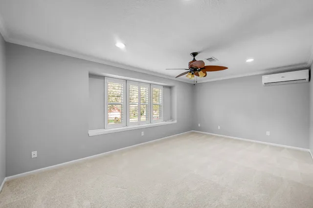 an empty room with window and a ceiling fan