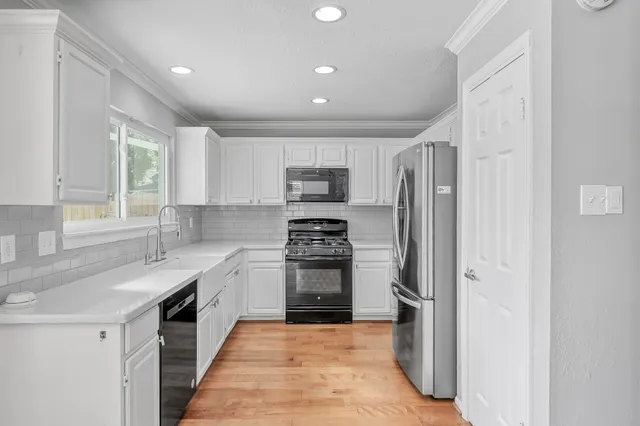a kitchen with stainless steel appliances granite countertop a stove a sink and a refrigerator
