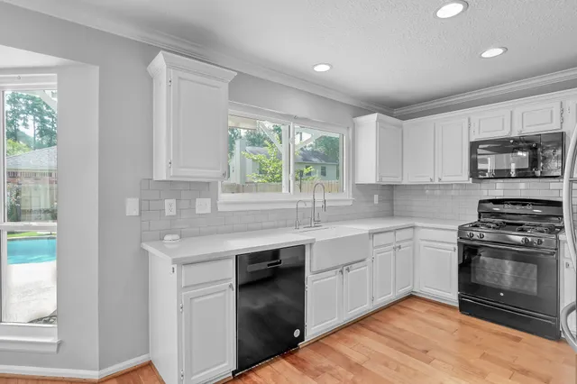 a kitchen with stainless steel appliances granite countertop a stove a sink and a microwave