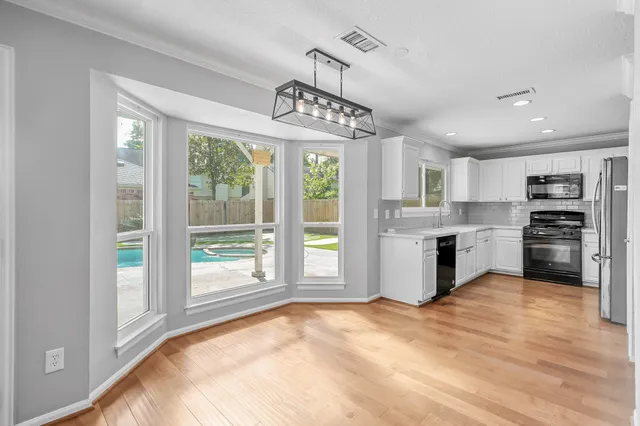 a kitchen with granite countertop a stove a sink and a refrigerator