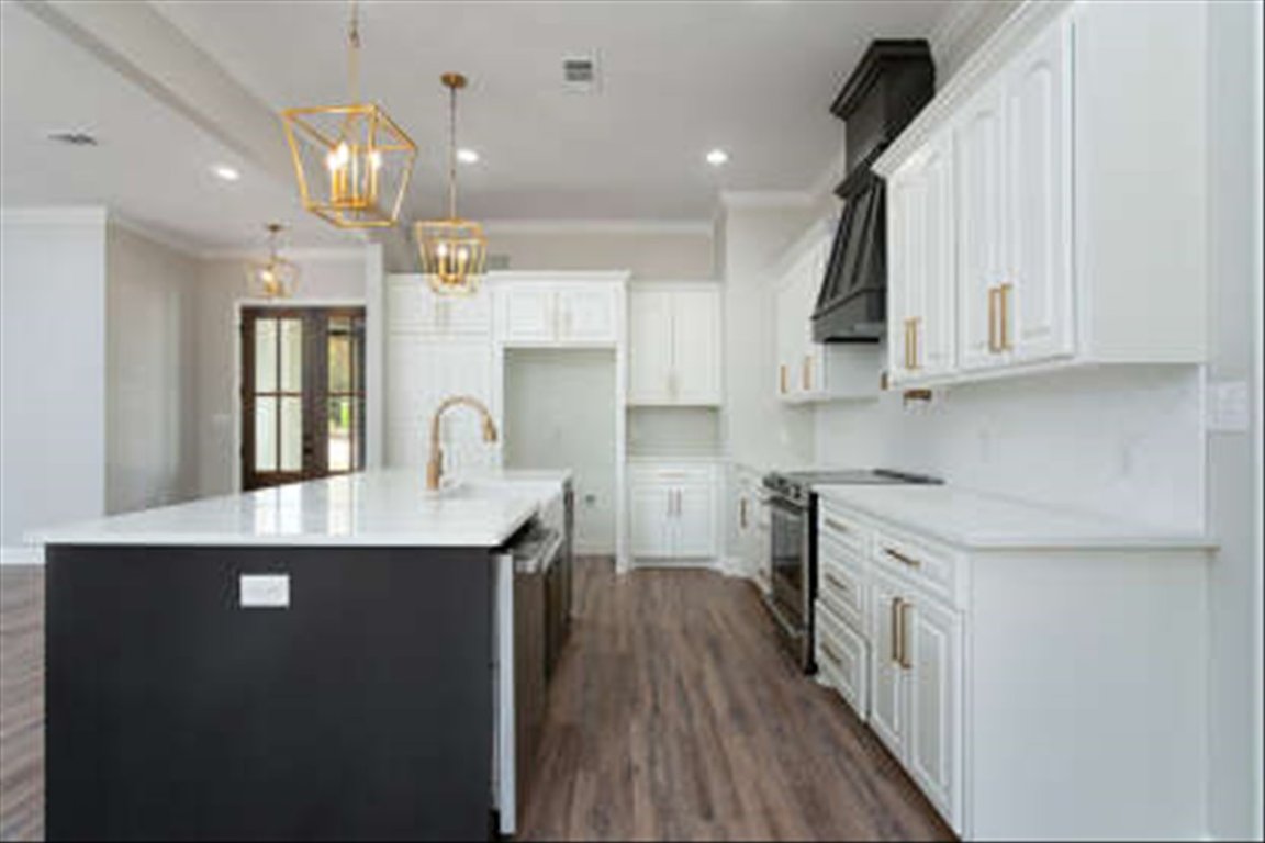 175 Impala Pass Rosanky, TX 78953 - Photo 4 of 16 a kitchen with kitchen island granite countertop a sink cabinets and wooden floor