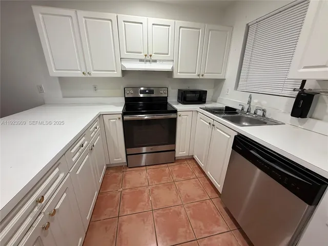 a white refrigerator freezer and a stove sitting inside of a kitchen