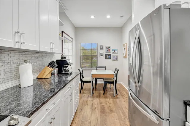 a kitchen with granite countertop a sink stove and refrigerator
